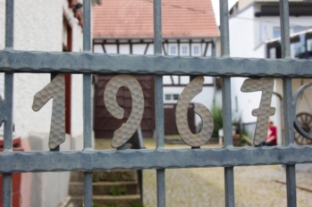 Schmiedeeisernes Tor des Heimatmuseums mit der Zahl 1967, dahinter der Hof